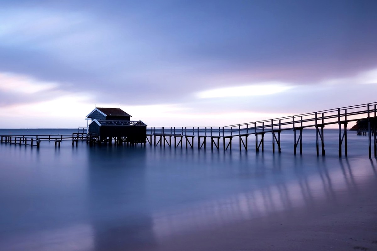 A quiet waterfront pier under a soft evening sky.