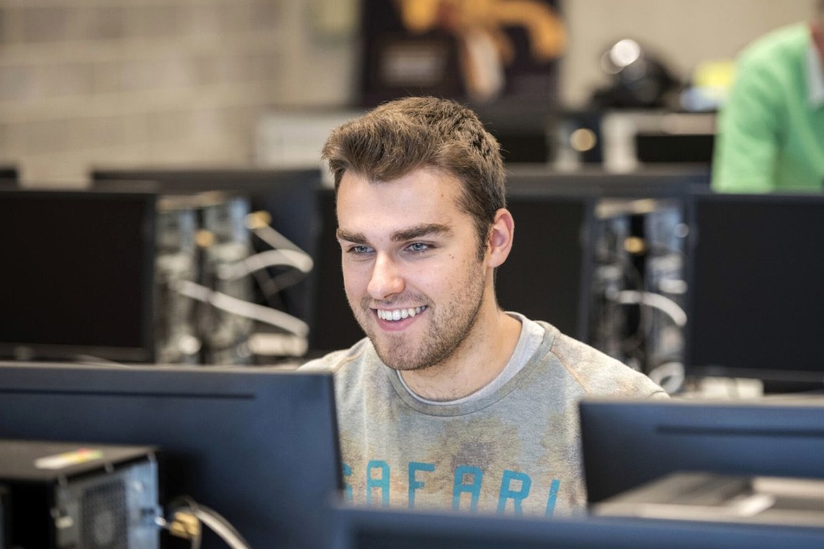 An editorial workspace with a person working at a computer.