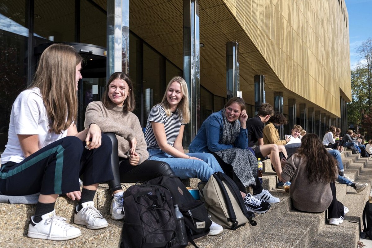 A group sitting outside a contemporary building during the day.